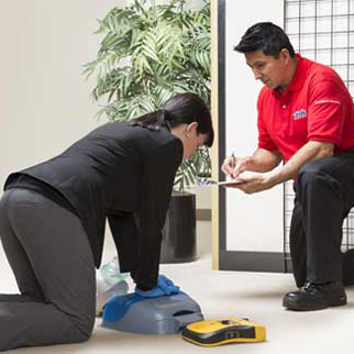 Cintas trainer teaching someone how to perform CPR